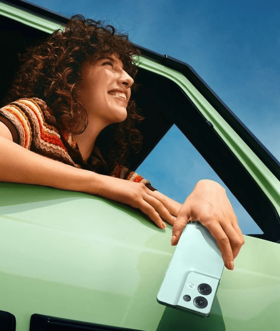 A person leaning out of a car while holding a phone